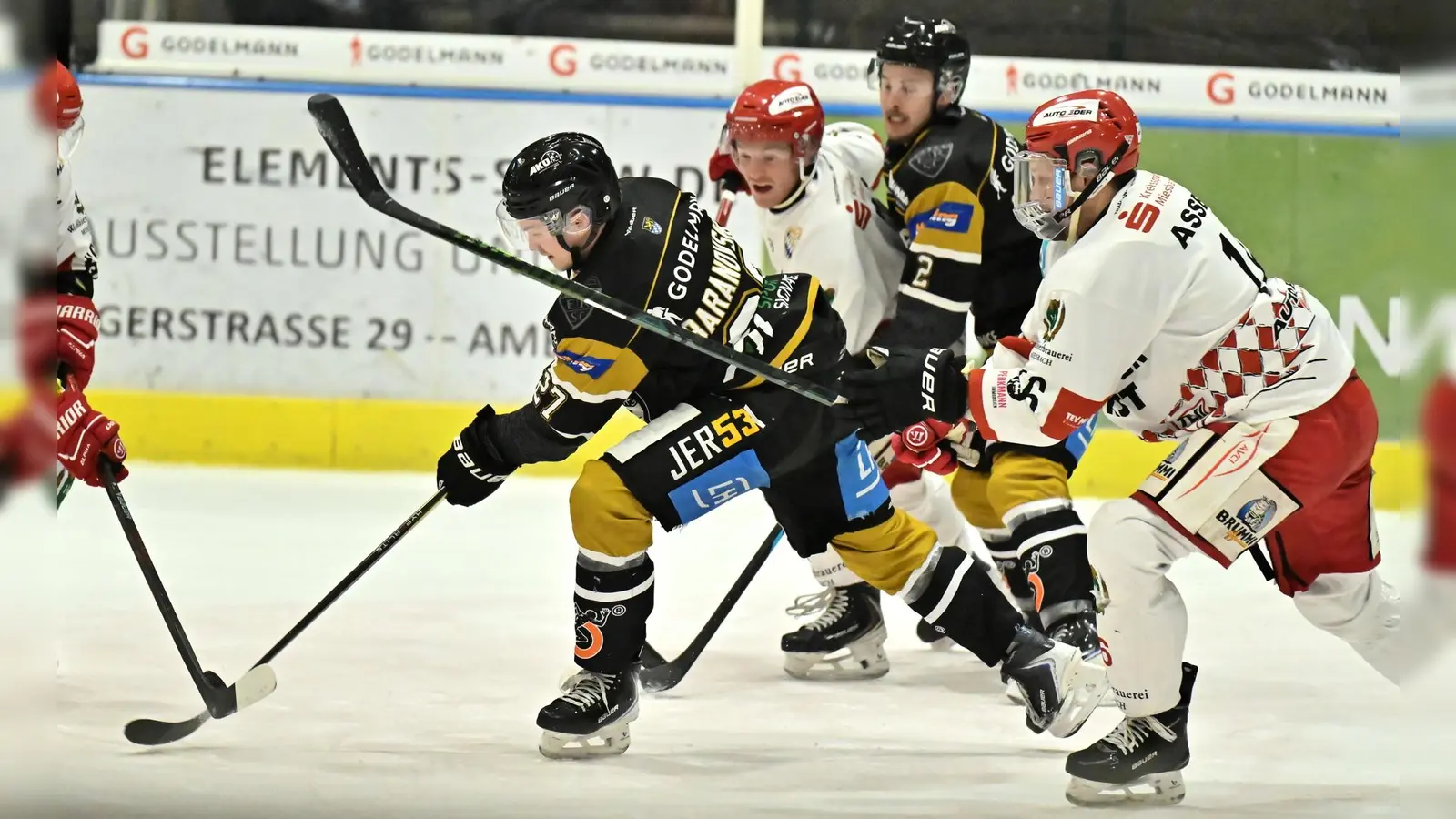 Roberts Baranovskis (Mitte) vom ERSC Amberg kann sich in dieser Szene an der Scheibe behaupten.  (Bild: Hubert Ziegler)
