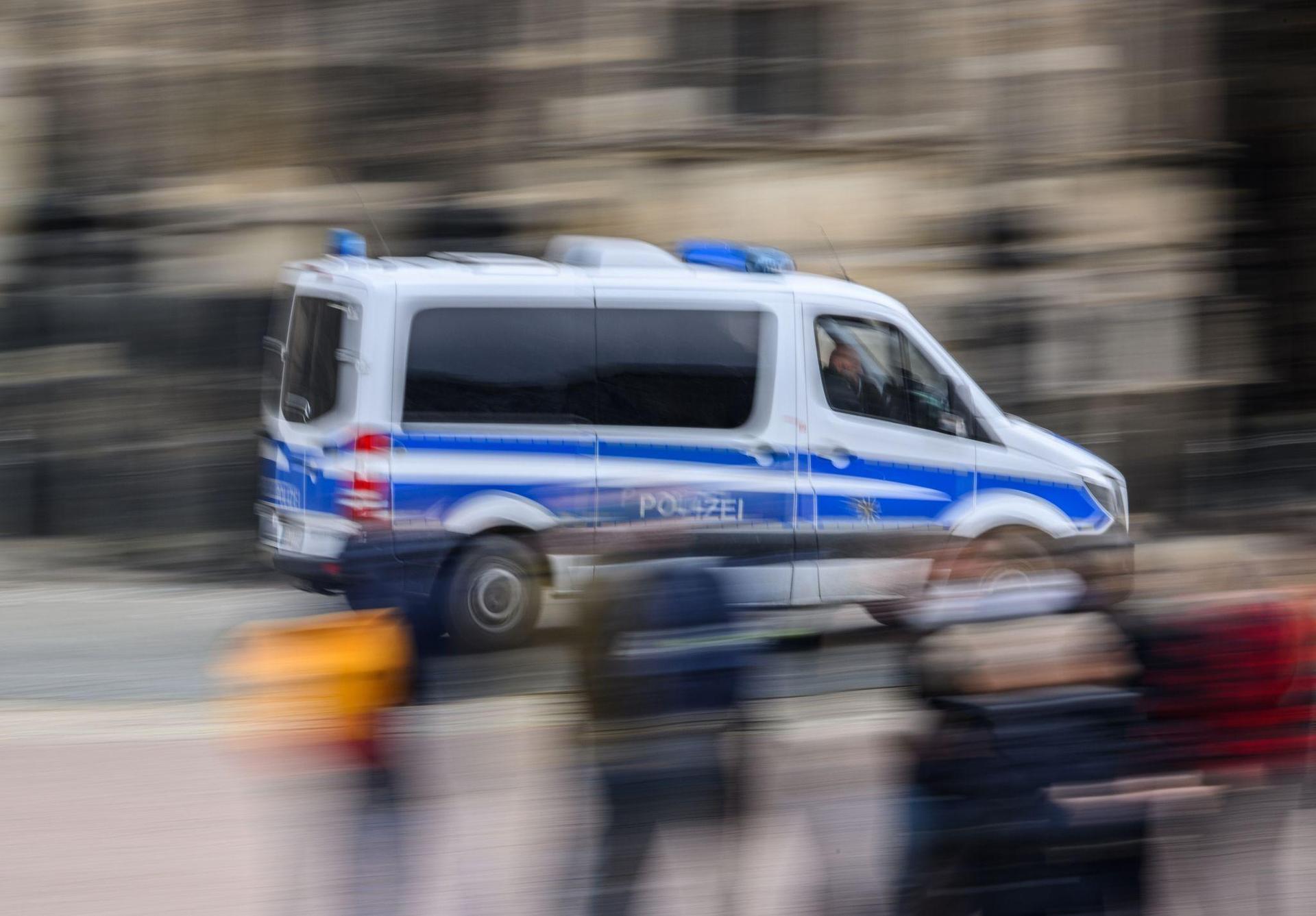 Ein Einsatzwagen der Polizei fährt durch eine Stadt. (Bild: Robert Michael/dpa/Symbolbild)