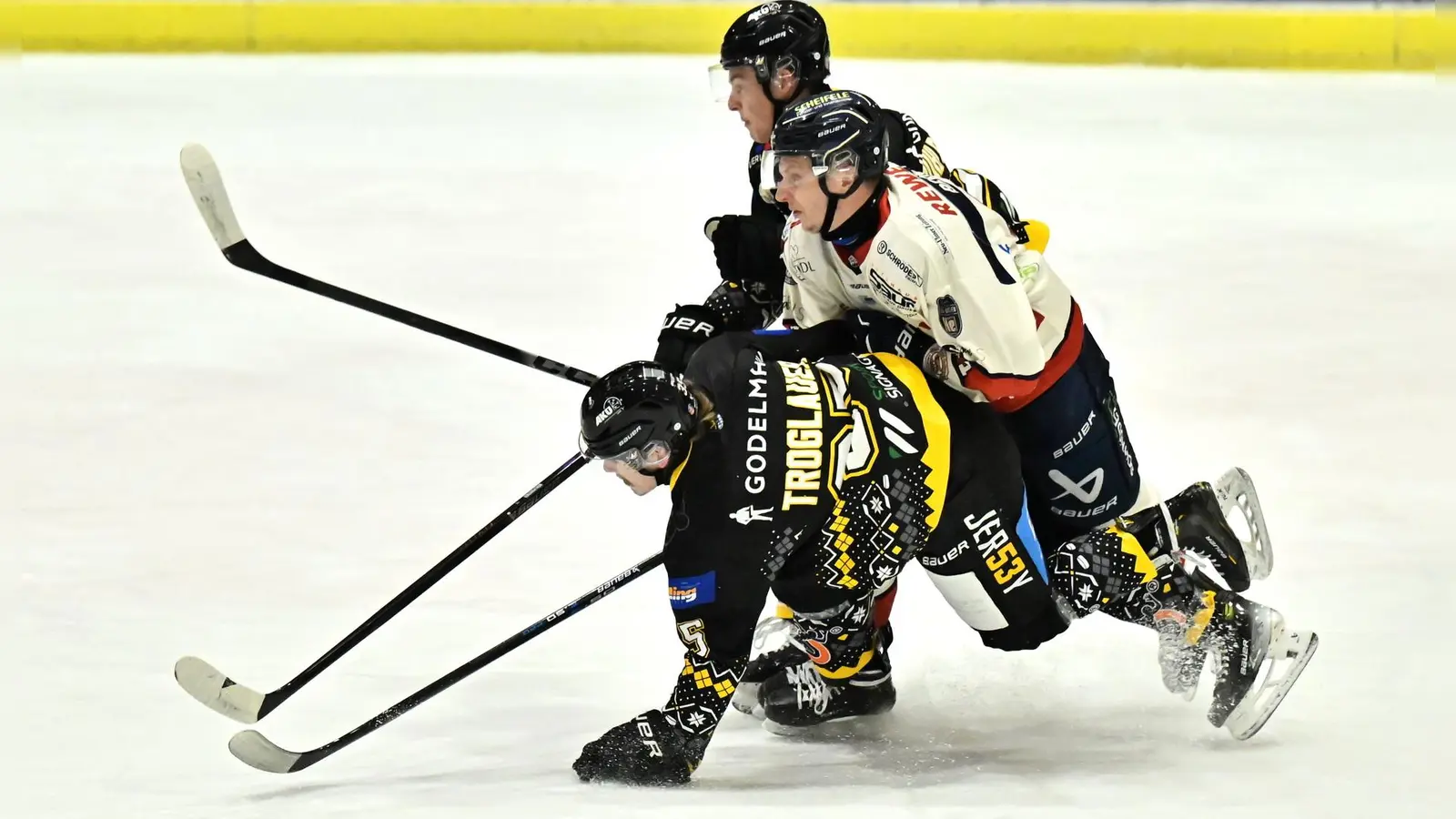 Nico Troglauer (unten) und Kilian Mühlpointner (oben) vom ERSC Amberg halten ihren Ulmer Gegenspieler von der Scheibe fern. (Bild: Hubert Ziegler)