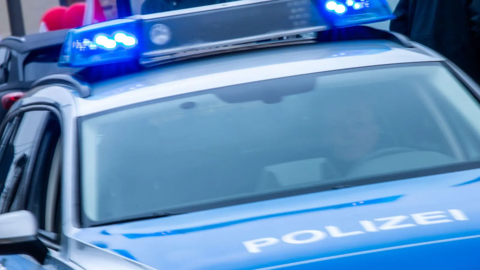 Ein Streifenwagen der Polizei ist mit Blaulicht im Einsatz. (Bild: Jens Büttner/dpa/Symbolbild)